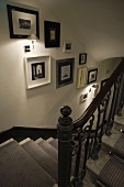 Stairway with ambient wall lighting and a collection of pictures