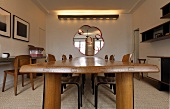 Living room with 50's style furniture -- long wood dining table and mirror with indirect lighting