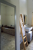Badezimmer mit Wandspiegel und angelehnter Holzleiter