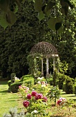 Gartenpavillon mit Säulen in blühender Gartenanlage