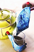 Tea glass in a decorative fabric tea glass holder and a tea pot handle