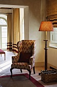 Wingback chair and floor lamp in the corner of a living room in an elegant country home