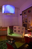 Corner of a living room with an eclectic mix of furniture and colorful lighting