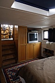 Cabin in a house boat with a built-in cupboard and stairs with a view of the steering wheel
