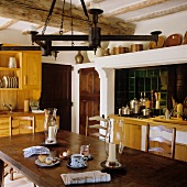 A kitchen in a country house with a wrought iron candle holder above a dark wooden table