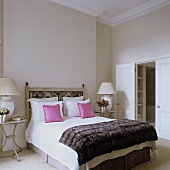 Englischer eleganter Schlafraum mit Blick in den Nebenraum-Antikes Doppelbett mit hochgezogenem Kopfteil aus Metall, gerahmt von Nachttischen
