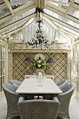 An elegant conservatory with grey wicker chairs set around a table