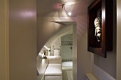 A play of coloured light and shadow in a bathroom and a Buddha head in a dark red frame