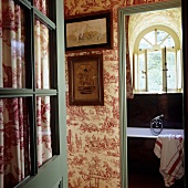 An open door with a view into a hallway and a bathroom in a French country house