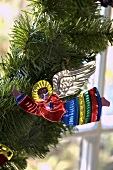 A colourful metal Christmas angel on a pine branch