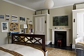 A bedroom with a fireplace between two built-in wardrobes against a grey wall
