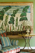 Striped upholstered chair with side table in front of a painting