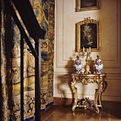 An elaborate Rococo table against a wood panelled wall