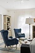 Blue upholstered winged armchairs in a living room