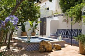 A tiled water fountain in a Mediterranean courtyard with potted plants