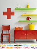 A collection of small, colourful items of furniture on and against the wall