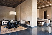 Offenes Esszimmer mit schwarzen Kunststoffstühlen und Blick in offenen Wohnraum eines Mediterraner Landhauses