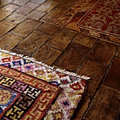 A brightly patterned rug on a terracotta floor