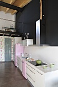 An open-plan kitchen - a kitchen counter in front of a black wall and view of a gallery