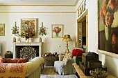 A living room in a country house with a fireplace, pictures of flowers and comfortable, upholstered armchairs