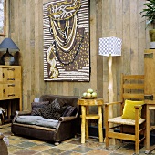 A rustic room with a leather armchair and handmade furniture in front of a wooden wall
