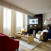 Wohnraum mit Sofagarnitur vor Fensterfront und aufgesetztes Lichtband an der Decke