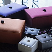 A set of fabric-covered boxes in various colours and sizes