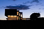 An illuminated, newly built villa by night