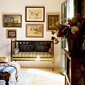 Antike Sitzbank und Bildersammlung an der Wand
