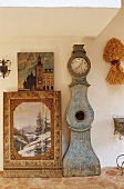 A picture and an antique grandfather clock standing against a wall cover in country house decorations