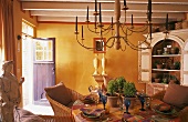 A country house atmosphere in a yellow-painted room - a chandelier and a laid table