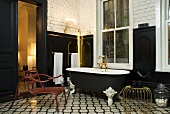 A bathroom with black wall panelling in a mixture of styles - metal furniture on black and white tiles