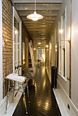 Artificial lighting in a corridor with a black shiny stripe on the wooden floor