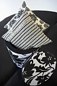 Patterned cushions in a black and white container with cover