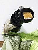 Stacked dark colored wooden bowl and green quilt