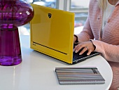 Woman using a laptop with yellow laptop cover
