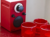 Radio mit rotem Gehäuse und Windlichter im roten Glas