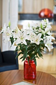 Bouquet of white lilies in a red vase