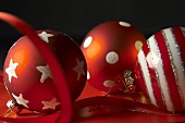 Three red and white striped Christmas baubles