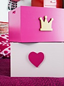 Pink and white wooden boxes with decorative motifs
