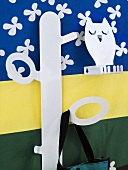 Kindergarderobe aus weißem Metall vor buntem Wandbehang