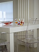 Modernes Esszimmer mit weißem Tisch und Stühle aus Plexiglas