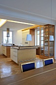 Double central island units in contemporary kitchen in front of display cabinet