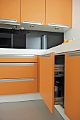 Moderne Küche mit orangefarbenen Fronten und Edelstahl Griffmulden