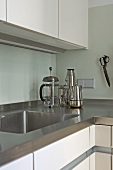 Corner of modern kitchen with stainless steel worktop