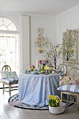 Osterdekoration auf Tisch und Stühlen mit Frühlingsblumen
