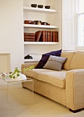 Transparent plastic coffee table in front of upholstered cream sofa