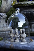 Chess figures made of stone under a bell jar in a garden