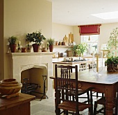 Essbereich mit antikem Holztisch, Stühlen und Kamin im der Küche eines Stadthauses