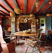 Holztisch mit Windsor-Stühlen und Kamin im Esszimmer eines Landhauses